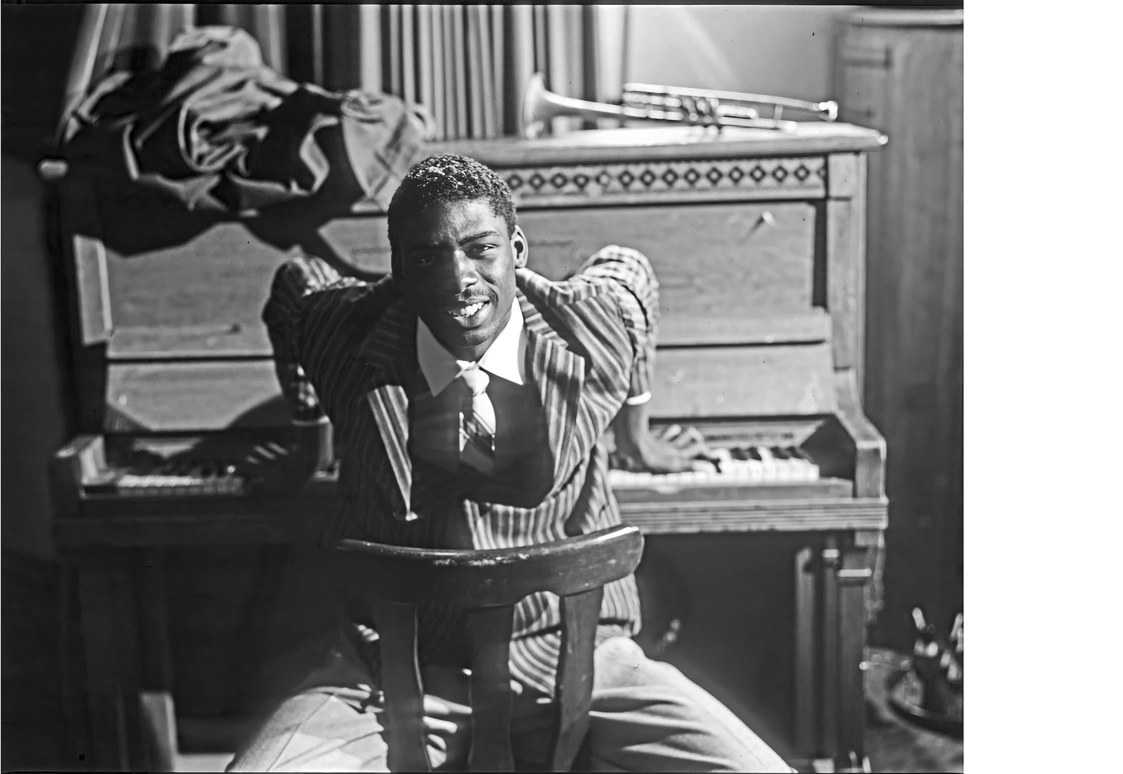 A man in a suit seated at a piano